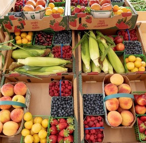 boxes and baskets of local fruit from local farms including Peaches, Sweet Corn, raspberries, blueberries, strawberries and mroe